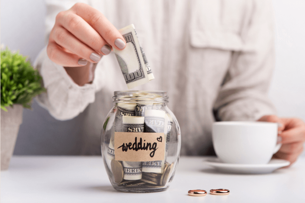 Concept of a person saving up for their dream wedding in a labelled jar with a view of wedding rings