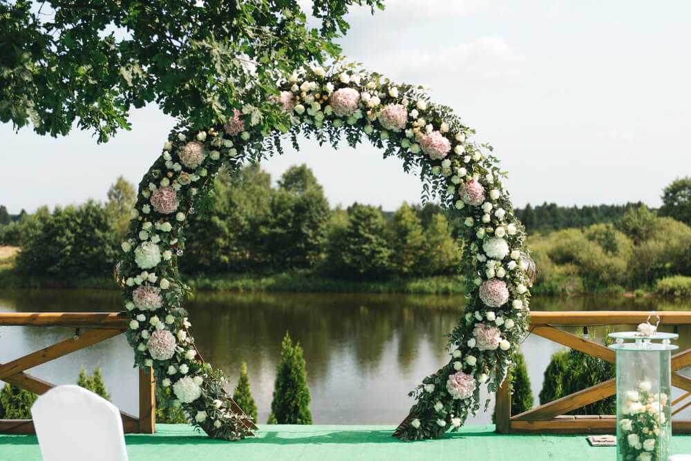 circular wedding arch and nature background of lake and trees