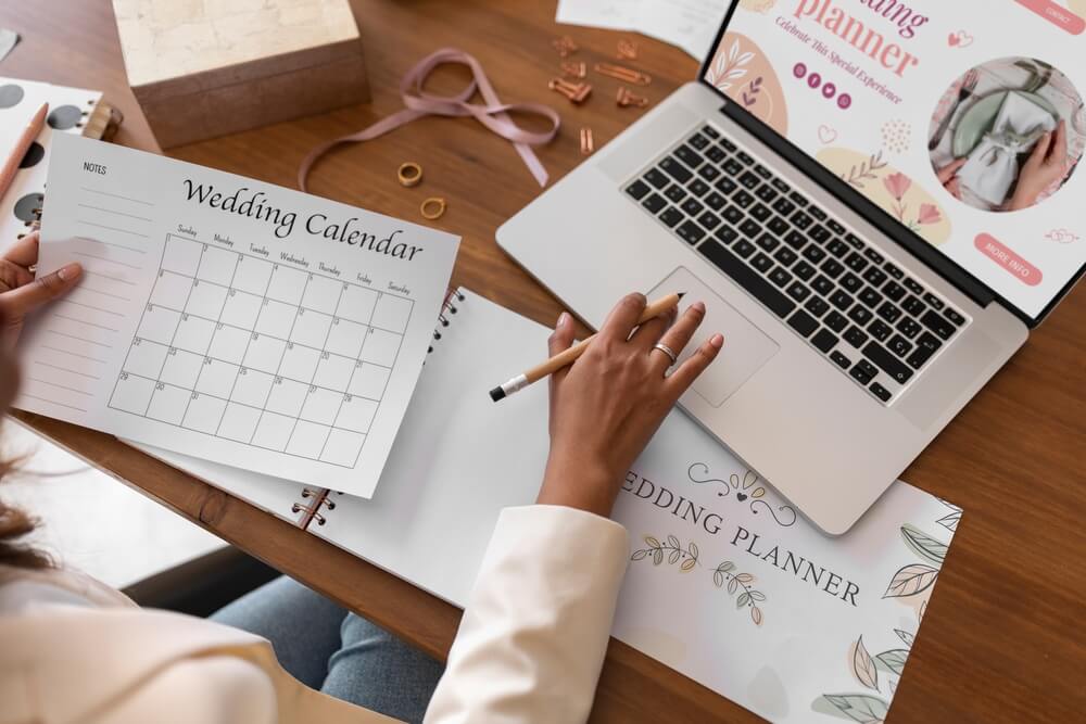 female wedding planner with laptop holding wedding calendar