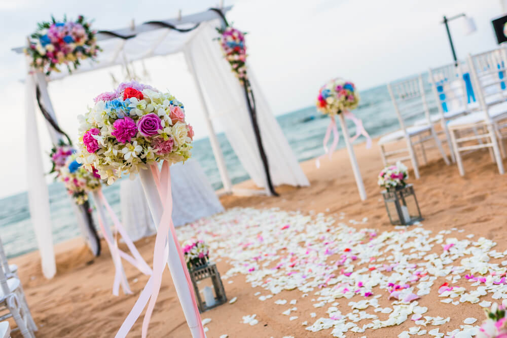 Romantic wedding set up along the beach with an aisle filled with flower petals