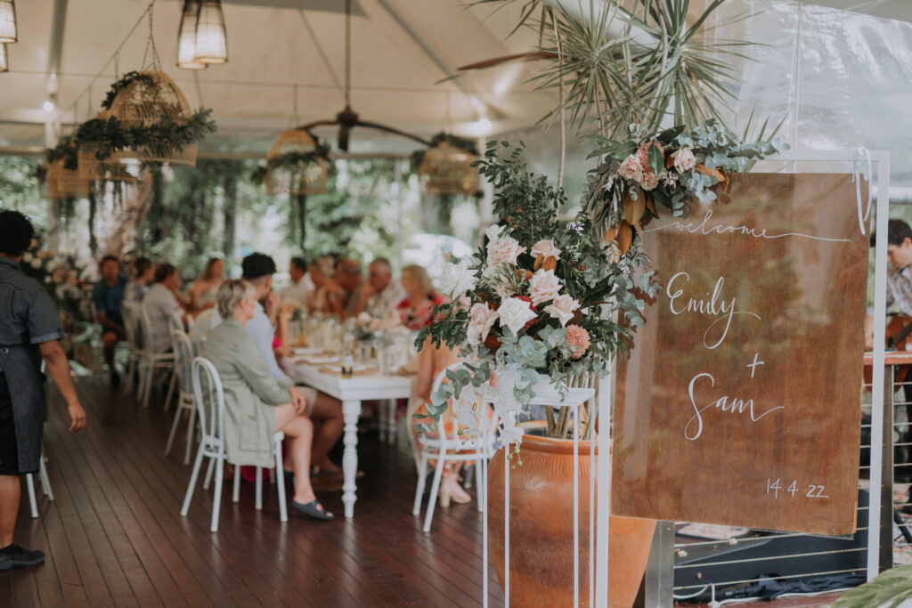 personalised wedding sign of bride and groom with wedding guests out of focus