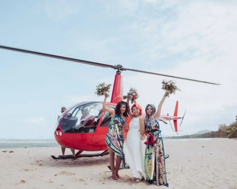 Bride and bridesmaids in front of the red helicopter after a grand entrance