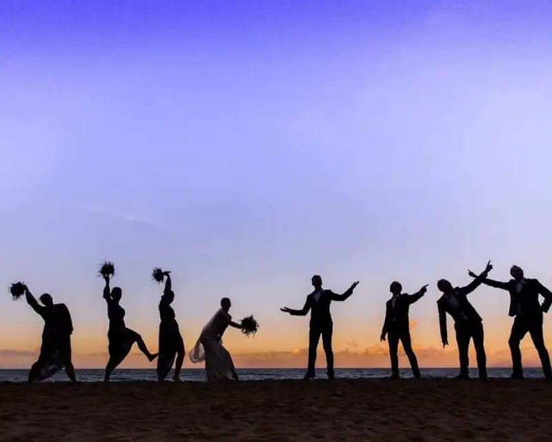 Silhouette of the bride and groom and their bridal party making funny poses
