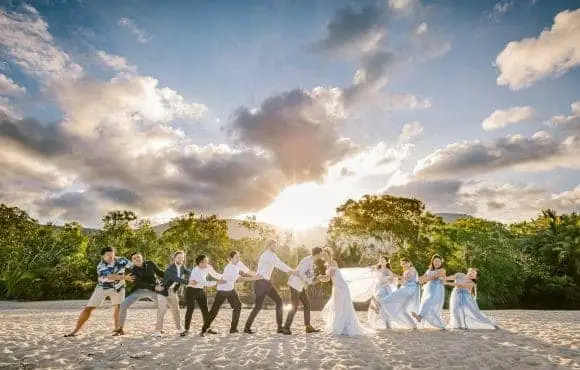 Wedding entourage posing on the beach in sunset