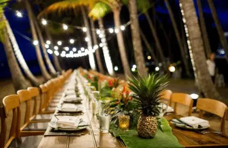 Tropical-themed tablescape with pineapples and leaves as runners