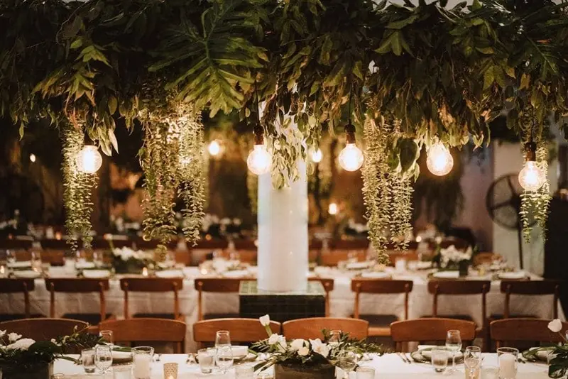 The reception area filled with traditional white flowers and a lot of wood chairs