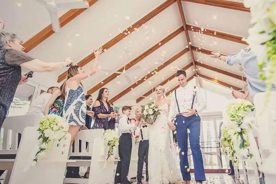 Chapel attendees throwing flower petals on newly married couple