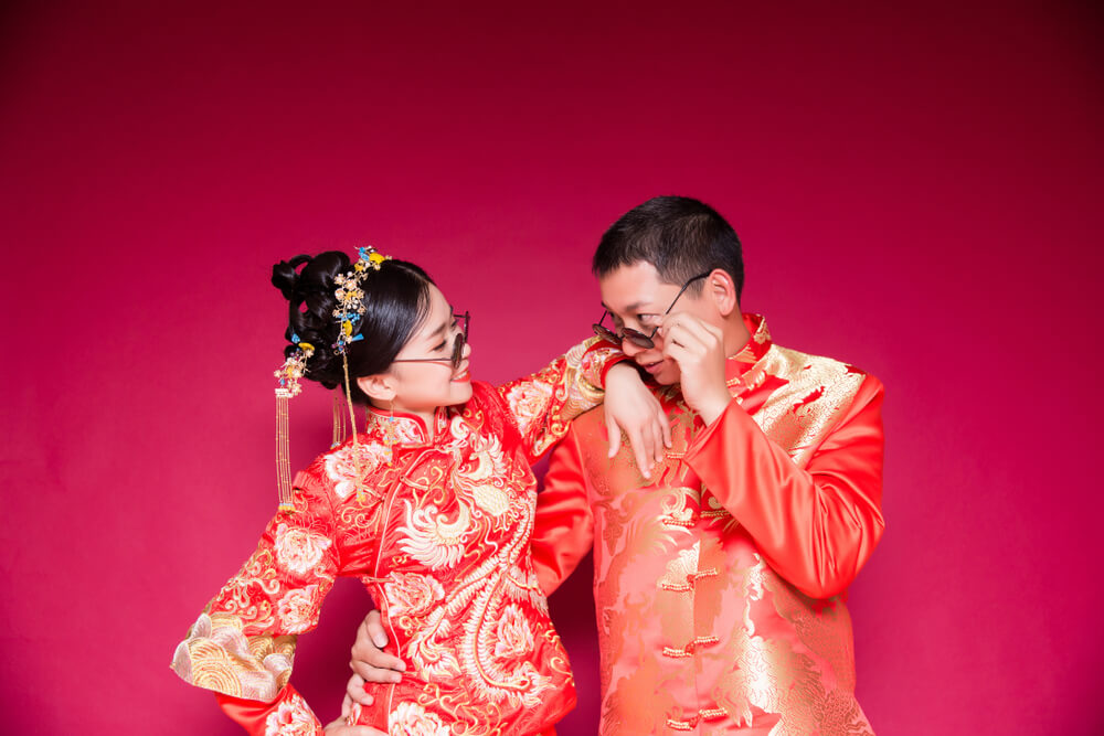 A bride and groom wearing fun modern Chinese wedding clothes