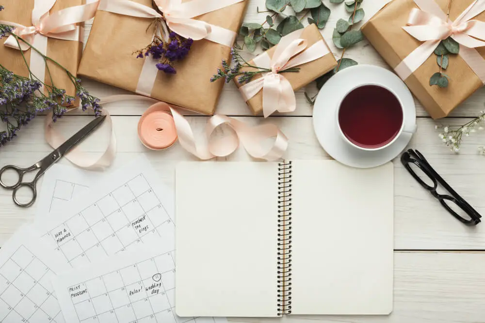 top view of wedding planning paraphernalia with wrapped packages and notebook